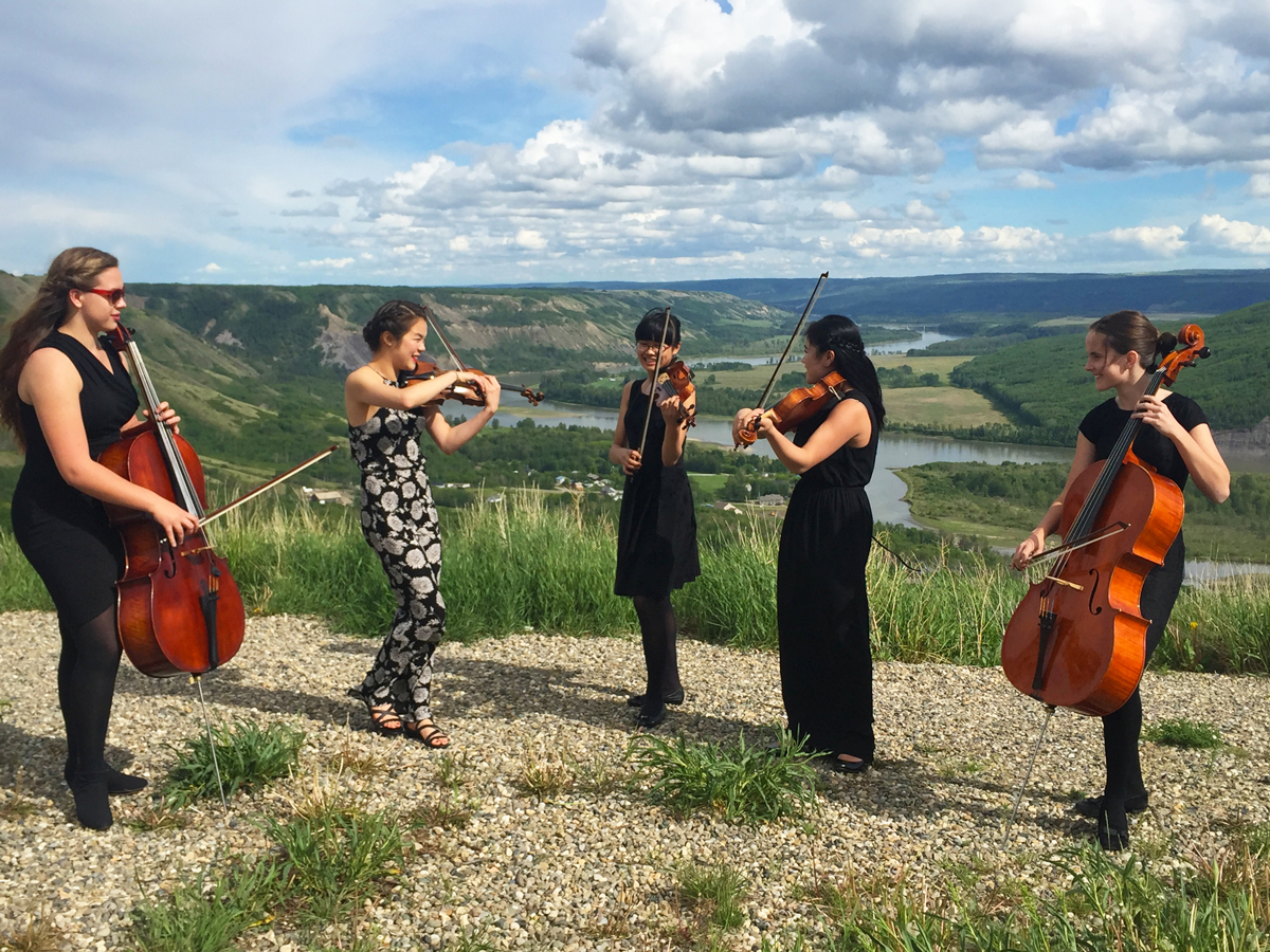 String quintet playing instruments outdoors