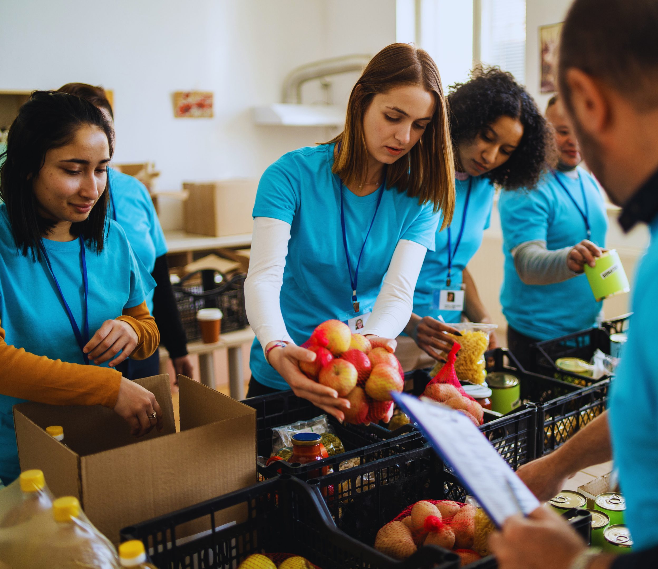People wearing blue pack food containers at a food bank.