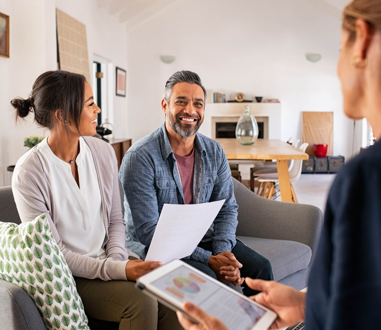 A financial advisor is meeting with clients in their living room to discuss their philanthropy.