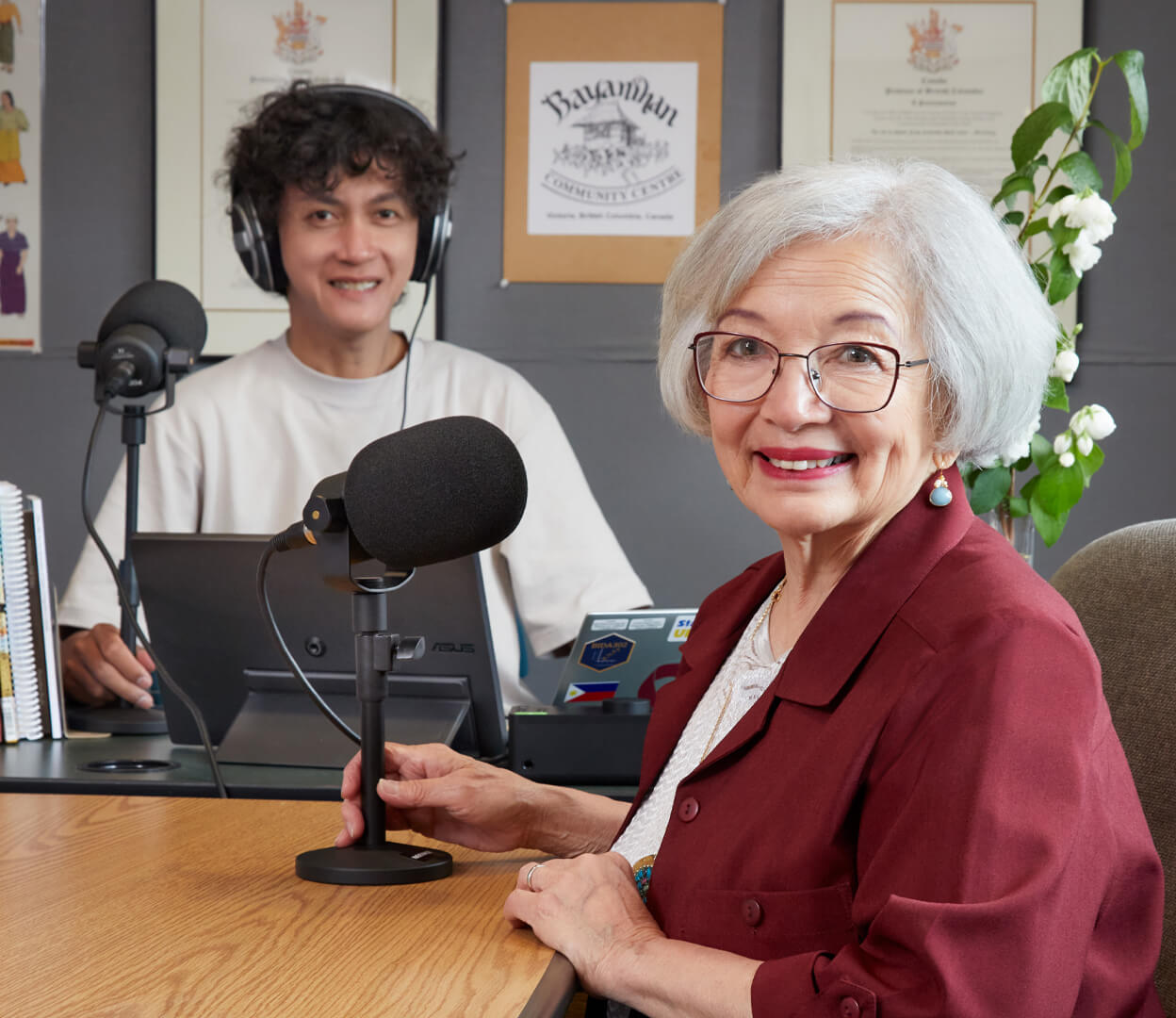Two people are sitting and creating a podcast for the Bayanihan Community Centre.