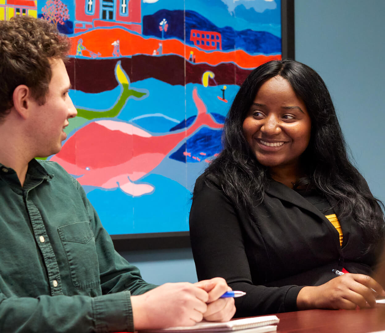 Work colleagues have a conversation in an office at the Victoria Foundation.