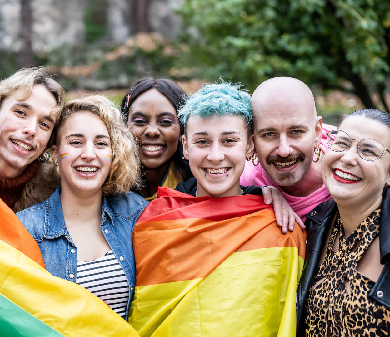A group of diverse people smile at the camera.