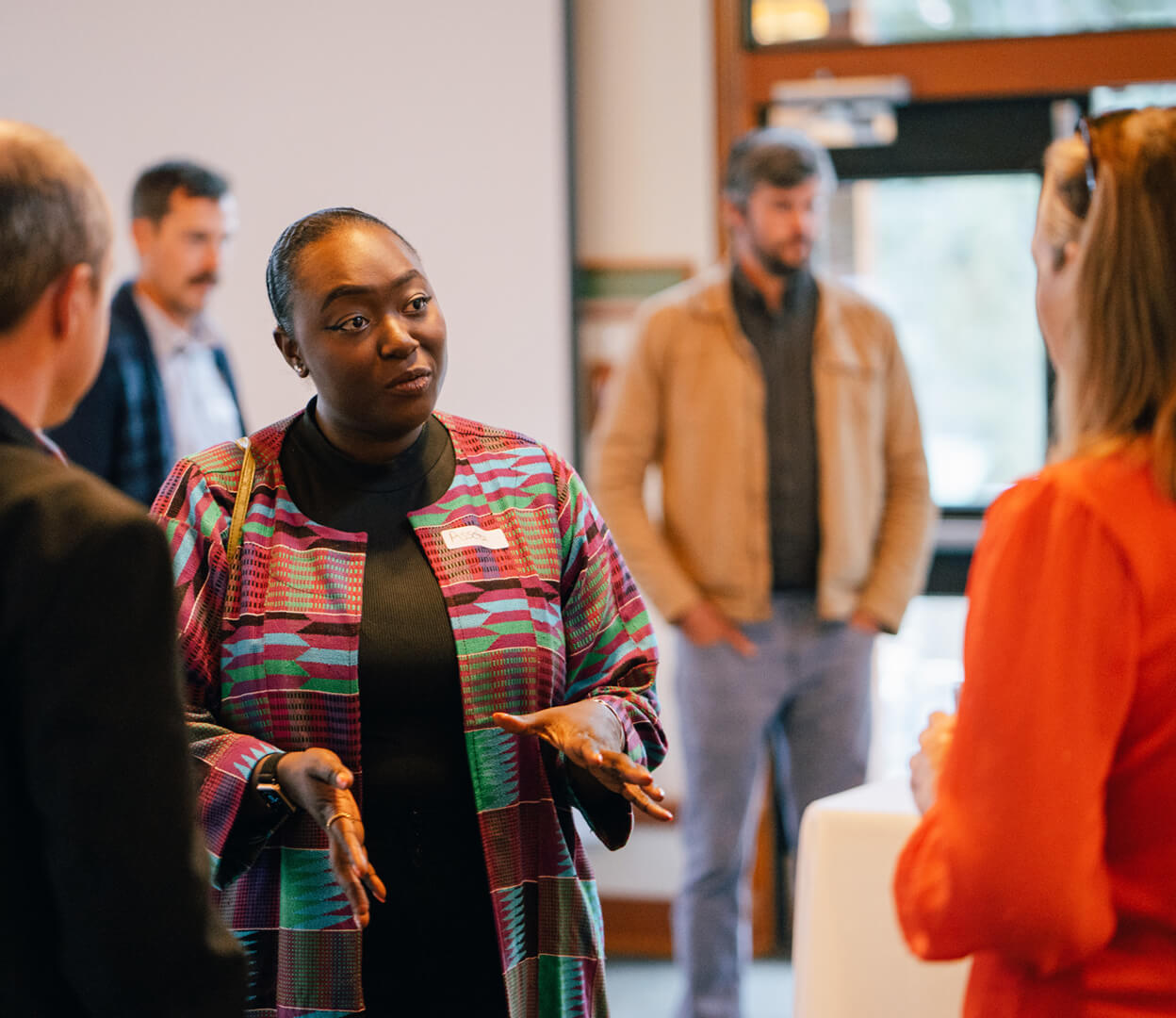 A woman converses with a group of people at a Victoria Foundation event.