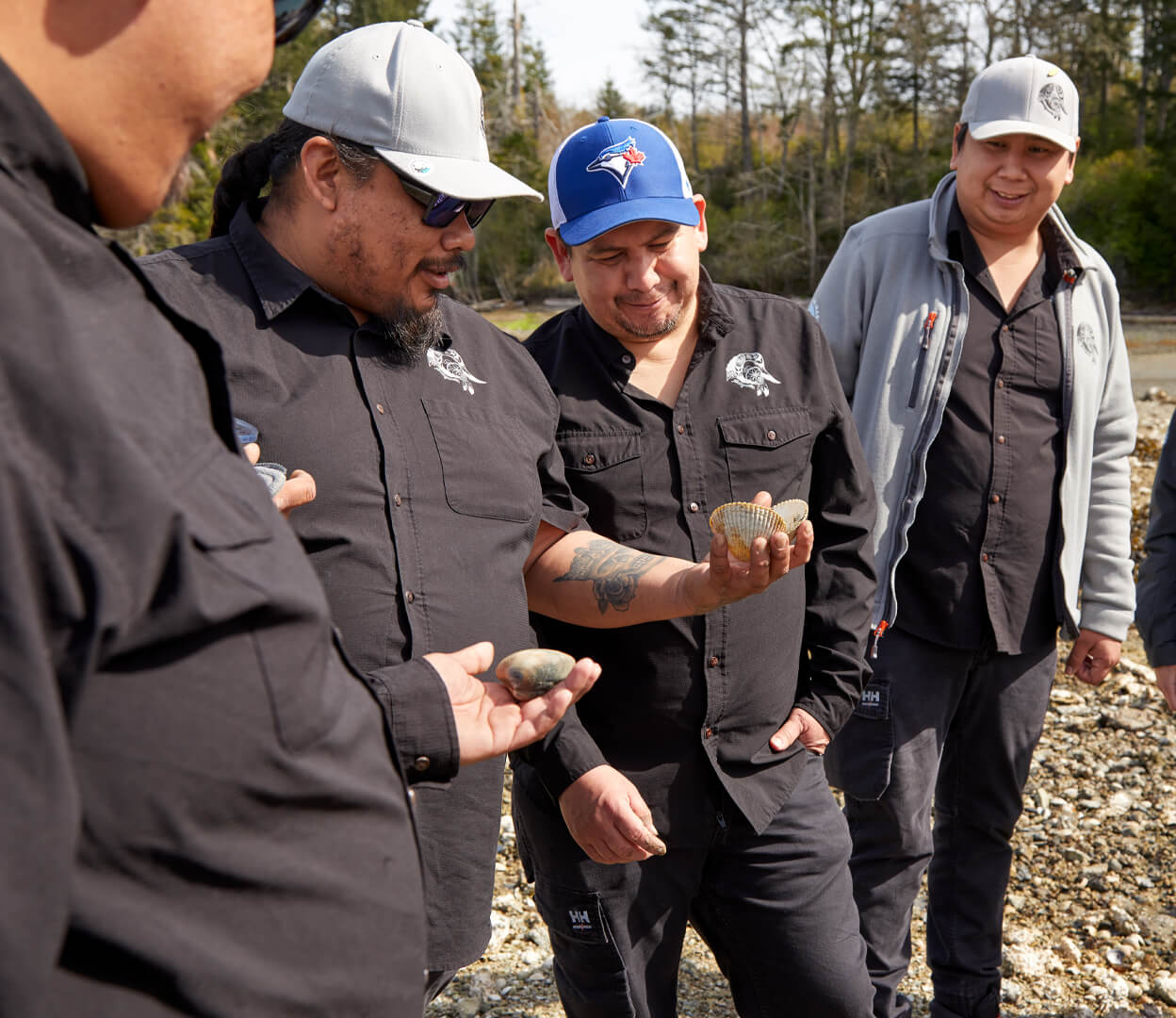 A group of Indigenous men are having a conversation in a riverbed.