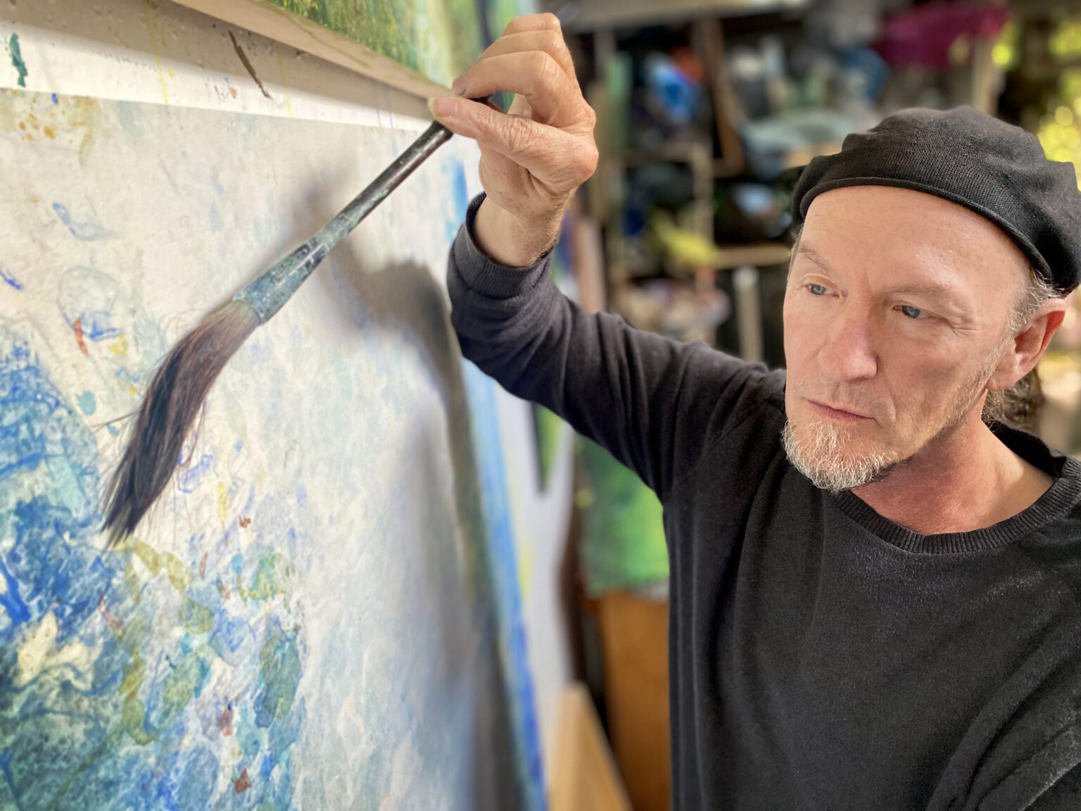 Artist Miles Lowry take a paintbrush to one of his paintings