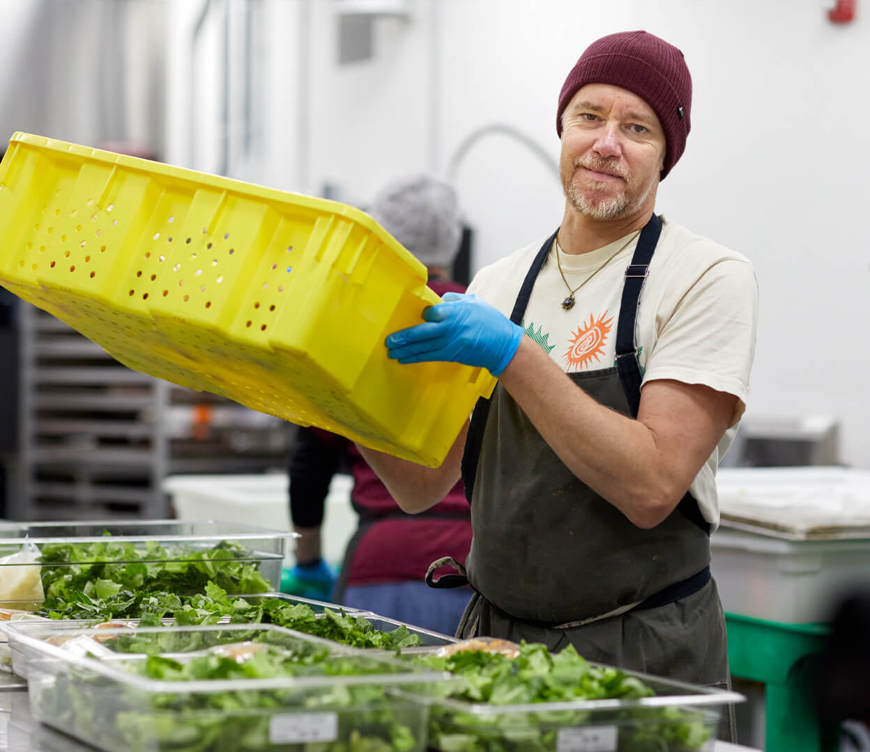A man looks at the camera while preparing food at the Mustard Seed Food Security Distribution Centre.