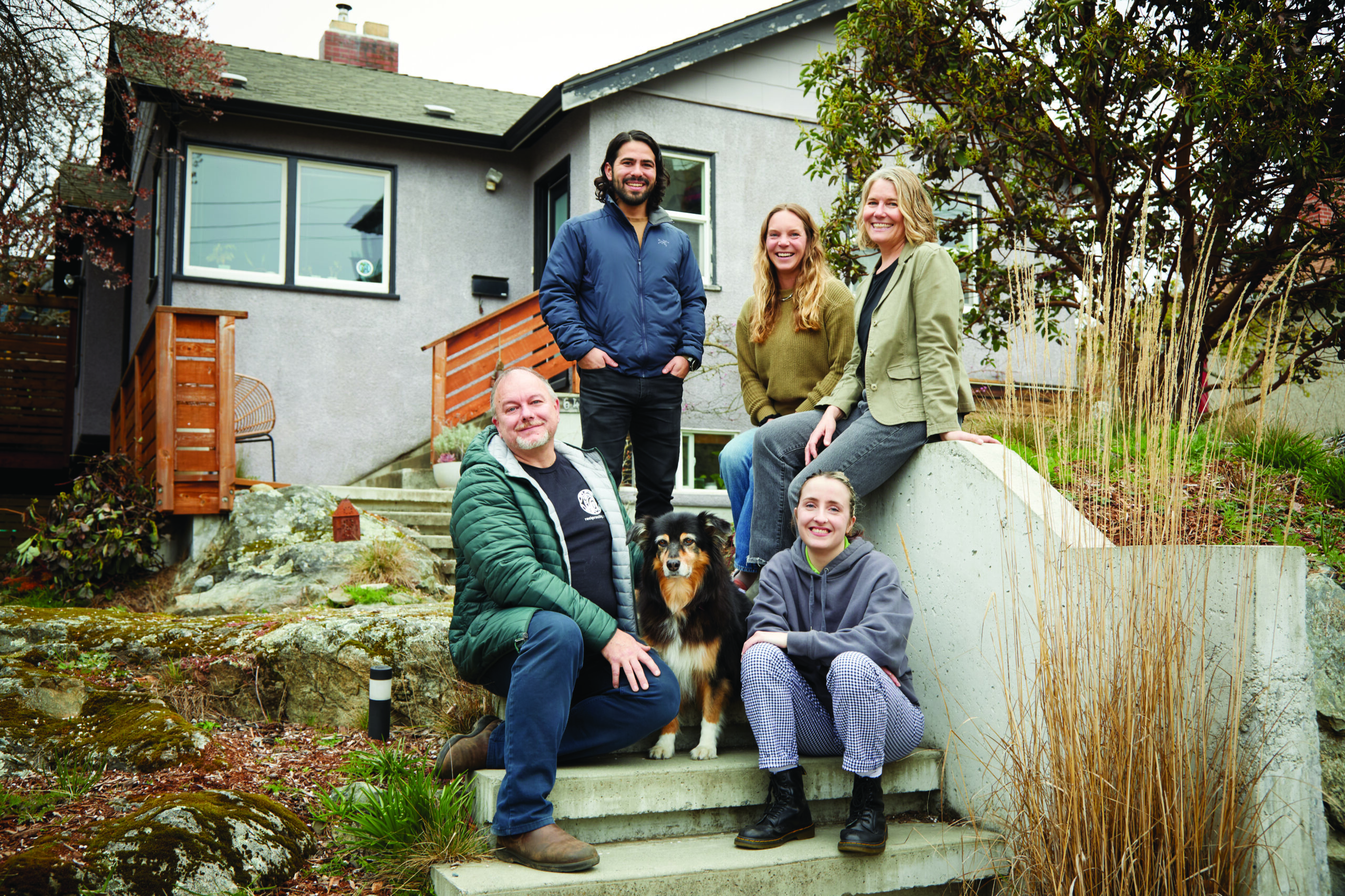 Reciprocity Trust team sit on steps with dog.