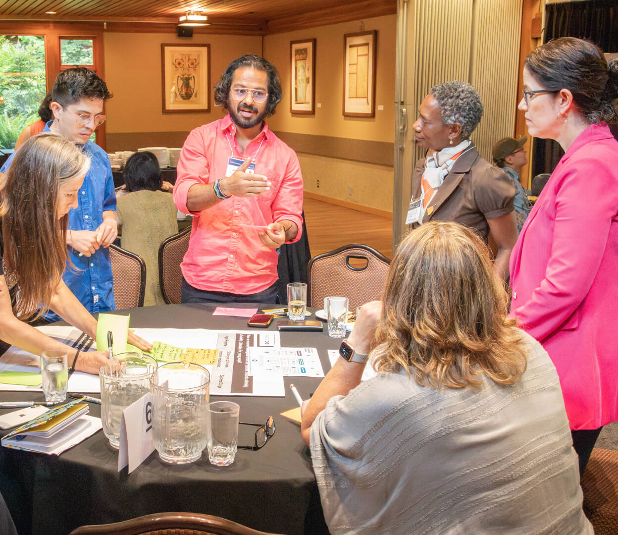 A group of people around a table having an engaging conversation at a Victoria Foundation event.