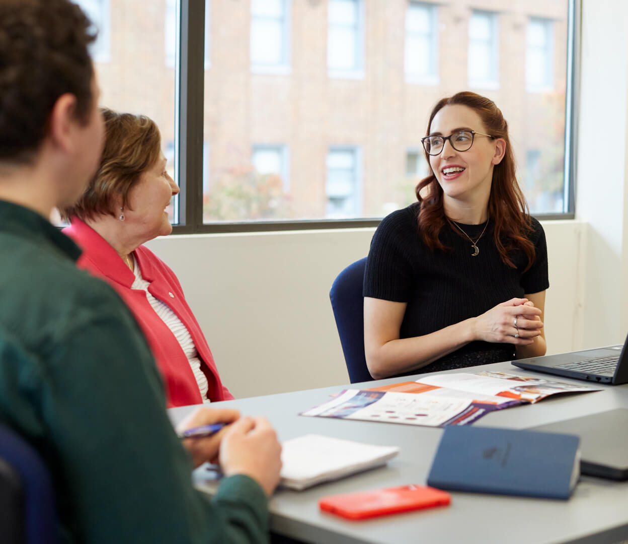 Work colleagues have a conversation in an office at the Victoria Foundation.