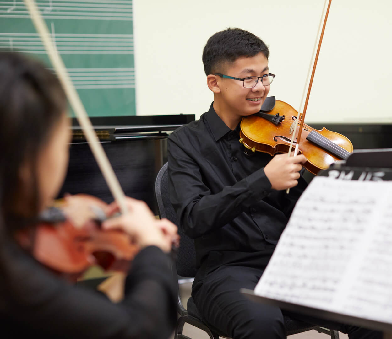 A group of young people play violin in a quartet at the Victoria Conservatory of Music.
