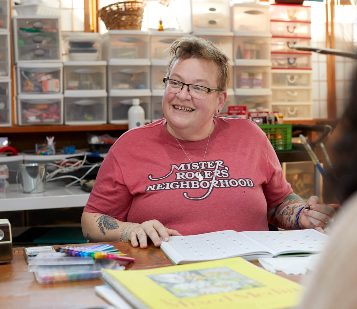 A person is smiling while participating in an art class at the Victoria Native Friendship Centre.