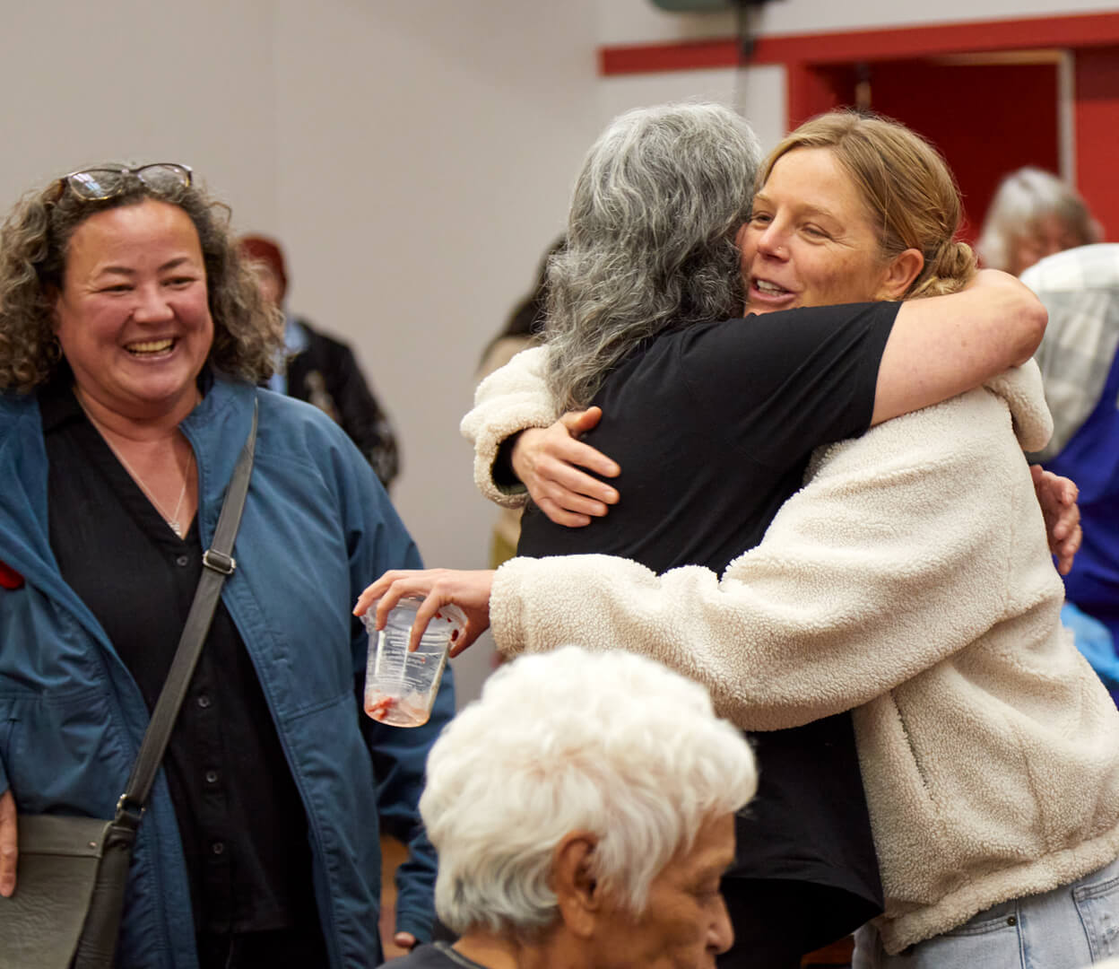 Two women greet each other with a hug during an event at the Victoria Native Friendship Centre.