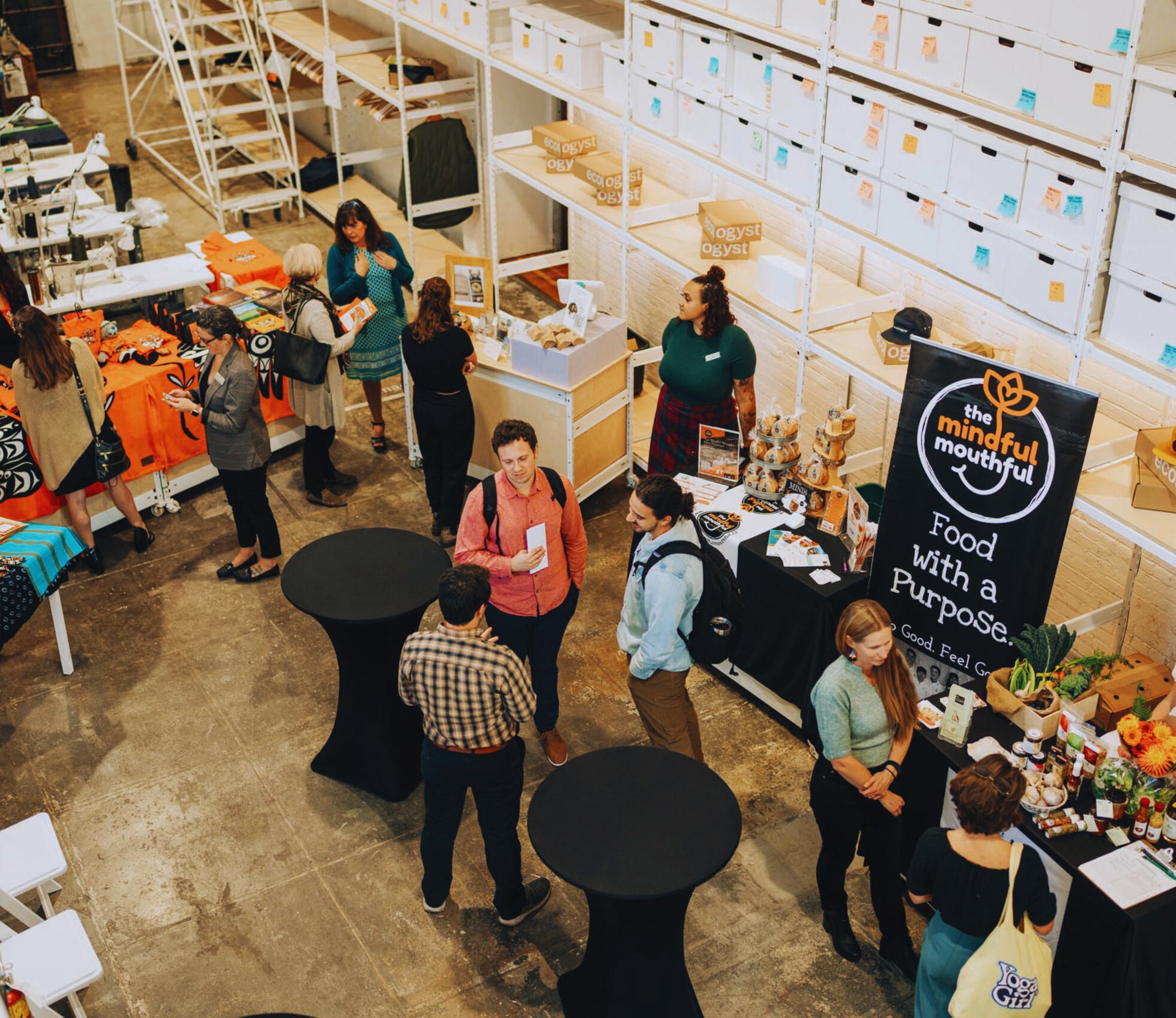Group of people mingle at an event in the ecologyst warehouse