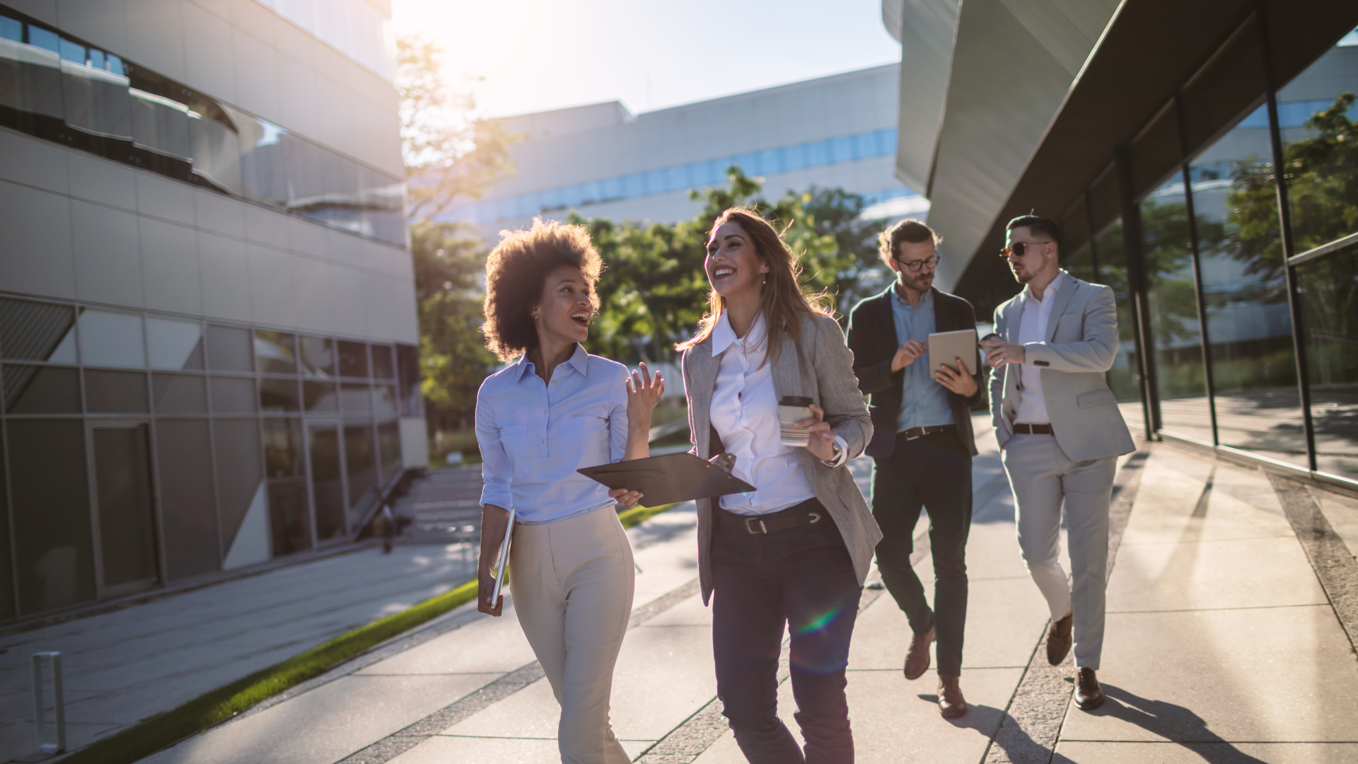 Professional advisors laughing and walking together outside.